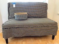 Front view of armless loveseat with gingham slipcover and matching basket on seat