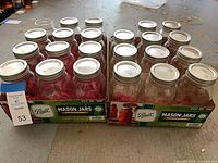 Two open cases each containing 12 Ball quart mason jars with silver lids