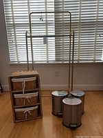 Full lot showing garment rack, wicker tower, three pedal bins
