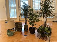 All items grouped together showing variety of faux plants, wicker planters and bird lamp
