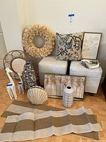 Full lot showing ottomans, mirror, wreath, vase, art, shell, giraffes, pillow, bead garland, table runners