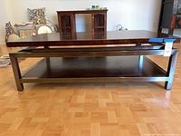 Full side view of rectangular coffee table showing wood top, metal frame, lower shelf