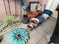 Group view of sign, turquoise metal flower, planters, pitcher