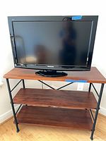 Front view of Panasonic TV on three-tier console