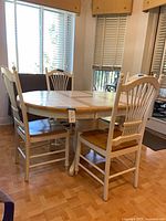Full view of tile-top pedestal dining table with four spindle-back chairs