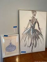 Large and small framed ballerina art leaning against wall