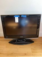 Front view of Sharp Aquos LC-26xxU TV on pedestal base