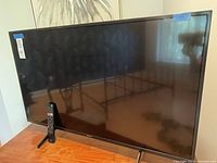 Front view of Sony TV on stand with remote visible