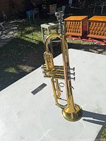 Full view of Conn 20B brass trumpet standing upright with mouthpiece attached