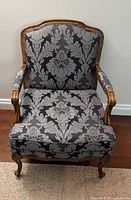Front view of armchair showing upholstery pattern and carved frame