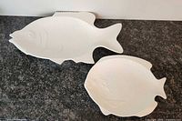 Both white ceramic fish platters on countertop