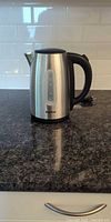 Full view of kettle front showing stainless body, water-level window, handle, base
