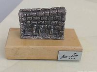 Front view of sterling wall sculpture with three figures on wood base and Ben-Zion plaque