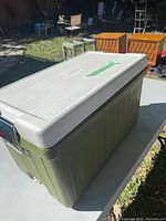Angled view of cooler showing green steel body and white lid