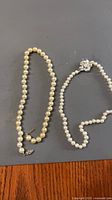 Two faux pearl bead necklaces laid flat