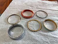 Six bracelets laid out on fabric showing variety