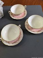 three double-handled cream soup bowls with saucers