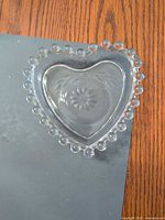 Top view of heart dish showing beaded rim and etched design