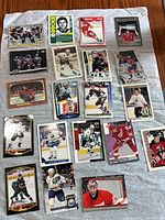 Group overview of roughly 20 assorted hockey cards laid out on cloth