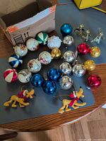 overview of entire assortment including box, ball ornaments, Pluto figures, metal angels