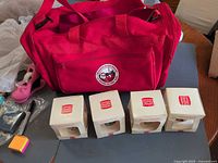 Group view showing red duffle bag and four Burger King ornament boxes