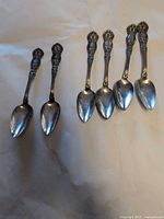 Six silver-plated teaspoons arranged on surface