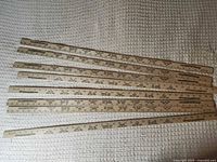 Eight wooden yardsticks laid out