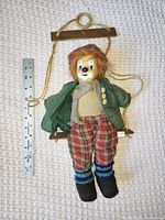 Full view of clown doll on swing next to ruler