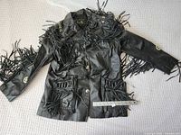 Front view of black leather fringe western jacket with ruler for scale