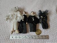 Group shot of all four clown dolls with ruler for scale