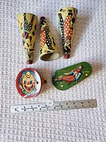 Front view showing three cone horns, round clown clicker, oblong green clicker with ruler for scale