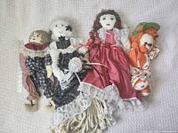 Group shot of four vintage cloth dolls showing overall condition and variety