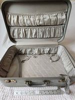 Suitcase open showing interior pockets and lining with ruler for scale