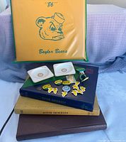 Stack of four Baylor yearbooks, ceramic dishes, pins, stickers, and stadium cushion
