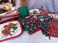 All items laid out showing variety of potholders, oven mitt, towels