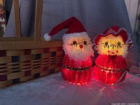Santa and Mrs Claus illuminated beside basket, cords visible