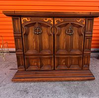 front view closed showing carved panels and brass pulls