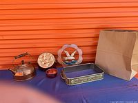 Group shot of all five items lined up: kettle, mold, measuring cup, stained glass, casserole holder