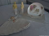 Group shot of bride and groom figurines, angel dish, 50th Anniversary plate on glass stand