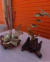 Both brass and burl wood sculptures side by side