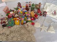 Group shot of all ornaments, wooden figures, lace runner and tea towel