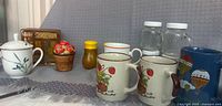 Overview of mugs, napkin holder, tomato basket shaker, amber shaker, mini glass shakers