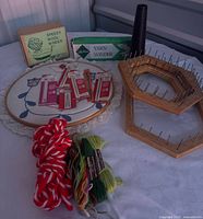 Full lot showing yarn winders boxes, hoop, needle packs, yarn skein, floss, looms, yarn cone