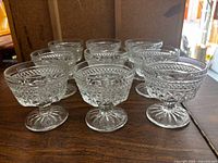 Group of nine identical Wexford pressed-glass stemmed coupes on tabletop