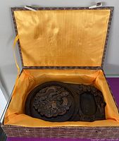 Open brocade box showing carved stone brush washer and oval ink well