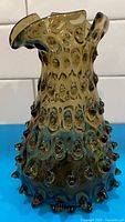 Front view of brown hobnail glass vase showing texture and form