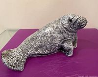 Right-side view of carved stone walrus showing full body and tail