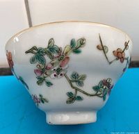 Side view showing floral enamel decoration and shape