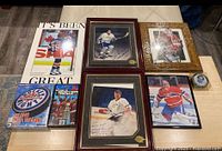 Overall view of lot showing framed photos, poster, board game, video game, and puck