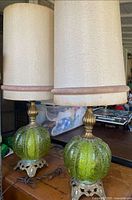 Both green glass globe lamps with tall shades
